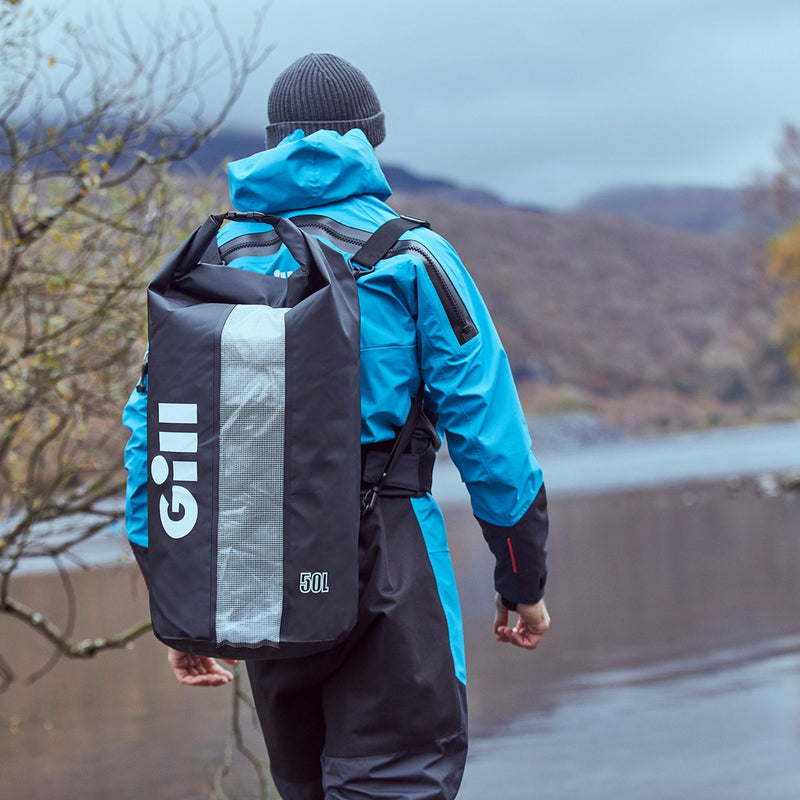 Lifestyle image of man carrying the 50L Gill Voyager Drybag on his back 