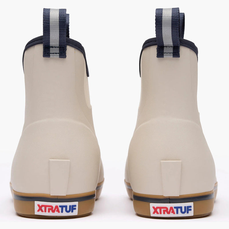 Pair of beige rubber boots with blue straps on a white background, featuring XTRATUF branding.