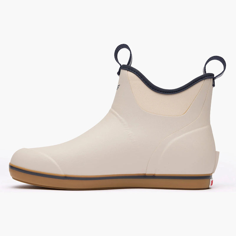 Beige rubber boot with black trim on a white background