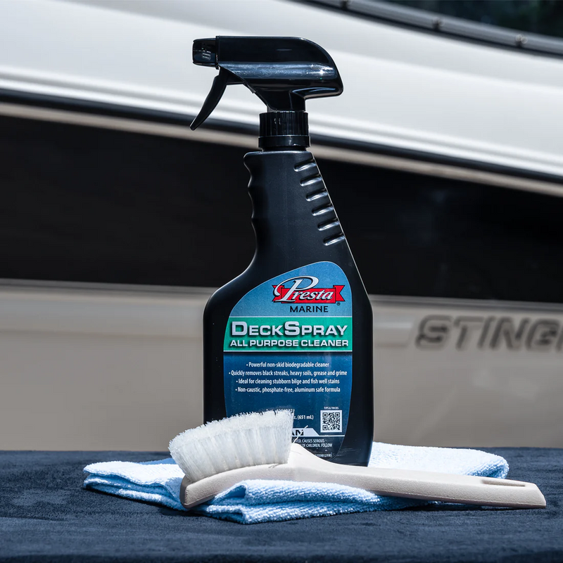 22 oz spray bottle DeckSpray All Purpose Cleaner shown on deck, with brush and cloth in front of boat
