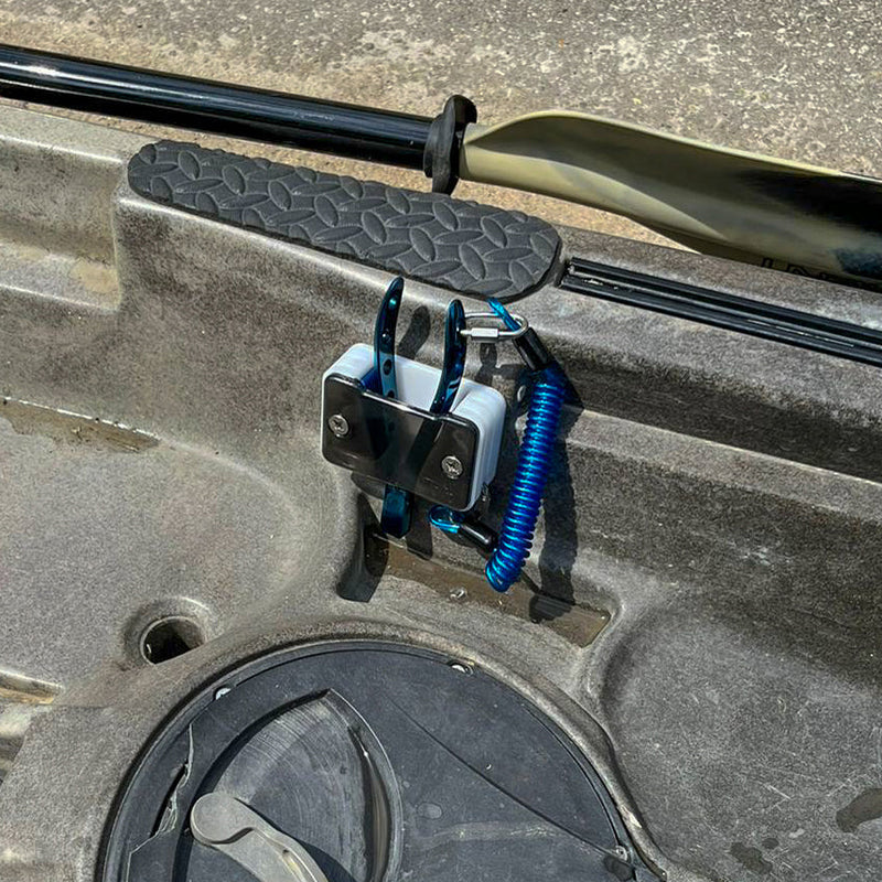 White pliers holder attached to a kayak
